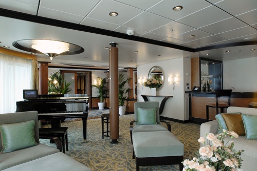 royal-suite Royal Caribbean features some 2,000 suites across its 20-ship fleet. The line will be unveiling a host of new suite amenities beginning in March. The Royal Suite, pictured here, features a digital baby grand player piano, a bar and panoramic sea views through a glass panel wall that spans the length of the suite. Image courtesy Royal Caribbean